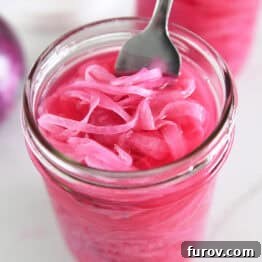 Fork in jar with red onions and vinegar.