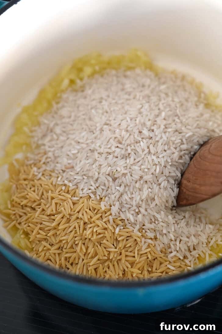 Long grain white rice and orzo pasta in butter and onions in cast iron pot.