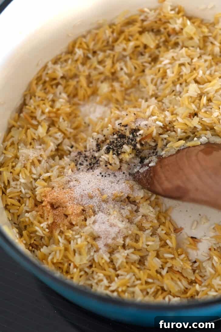 Garlic powder, onion powder, salt and pepper in pot with rice, orzo and butter.