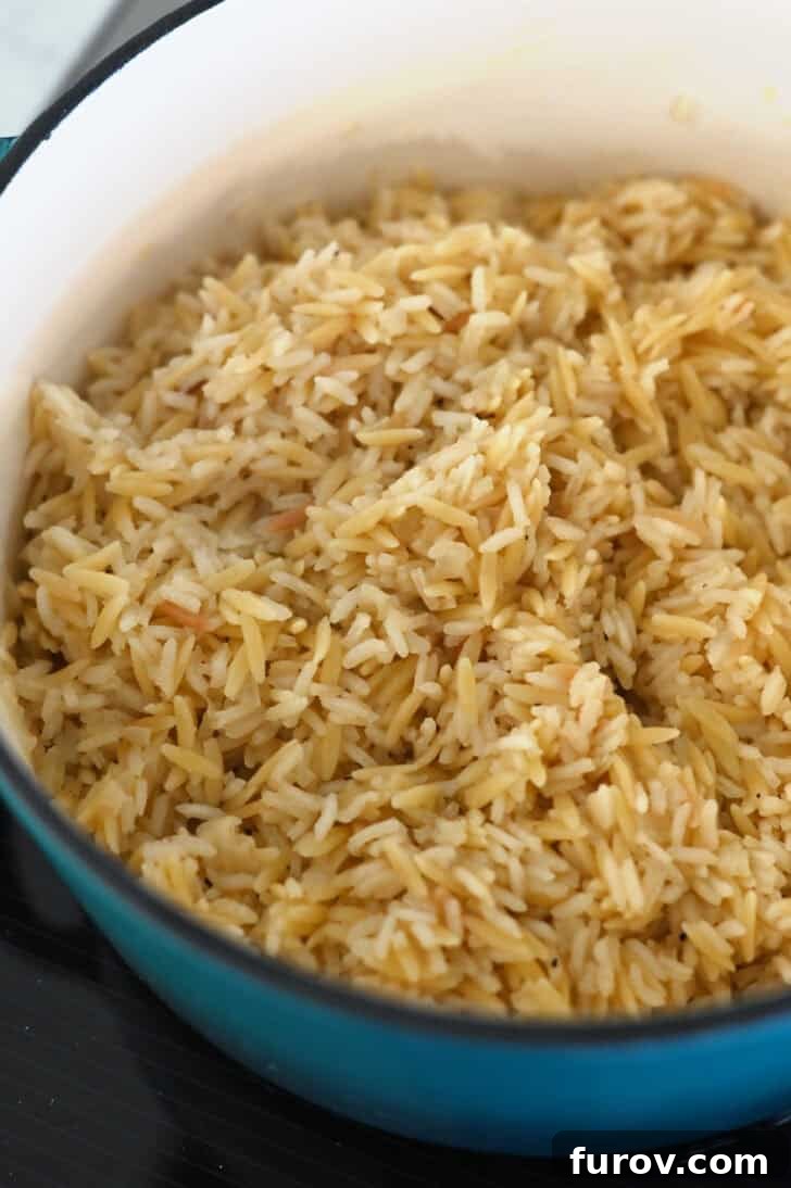 Fluffy, cooked rice pilaf in cast iron pot.