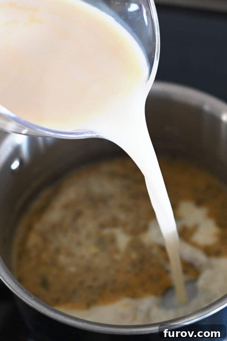 Pouring milk and broth into saucepan with flour and butter roux.