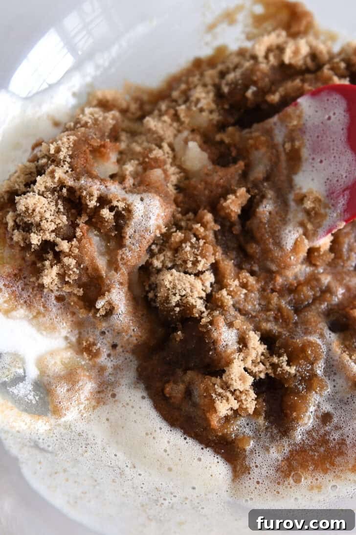 Melted brown butter combined with brown sugar in a glass bowl, ready for mixing.