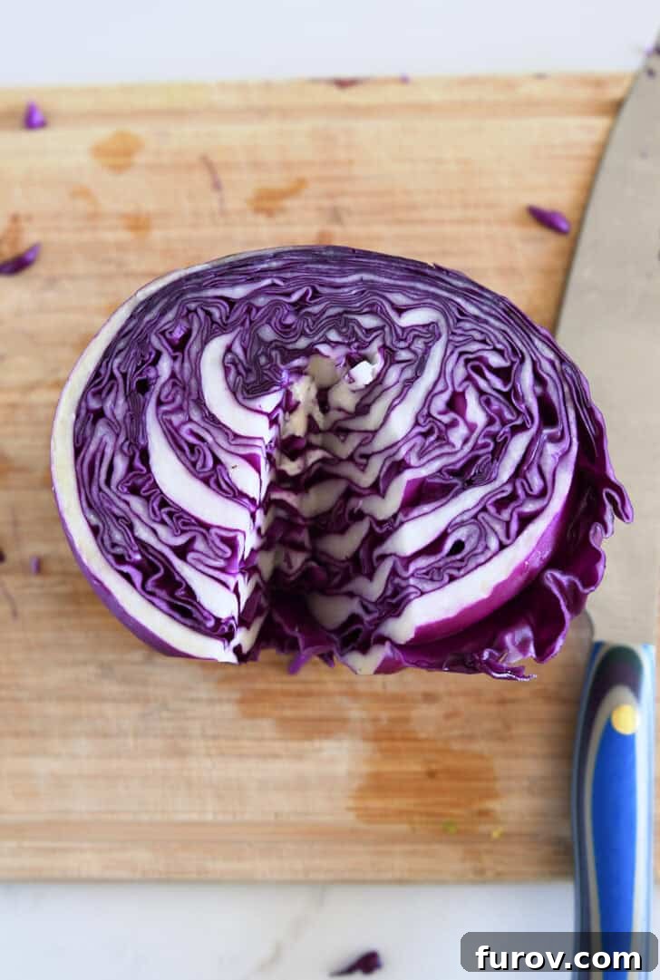 Red cabbage cut in half with the core expertly removed, prepared for slicing.