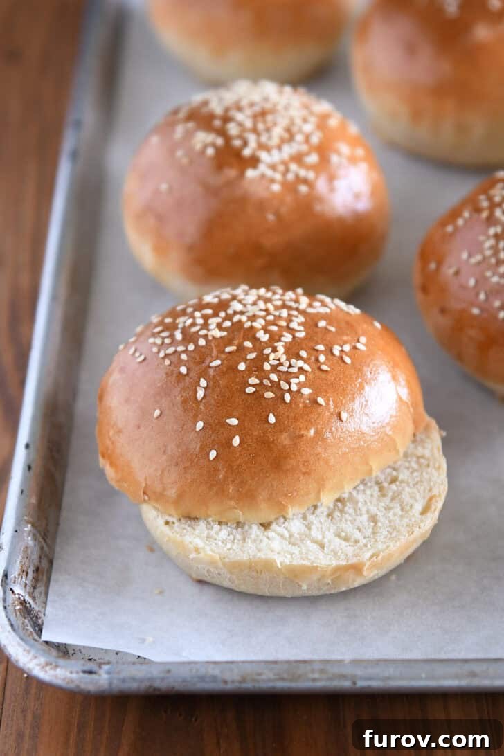 Golden baked hamburger buns with sesame seeds on top.