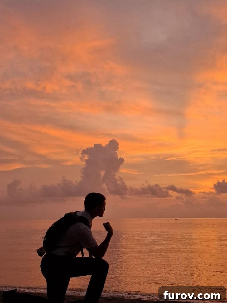 Friday Focus: My Current Chapter 6 The striking silhouette of a young man posing on a beach against a dramatic cloud formation, symbolizing adventure.