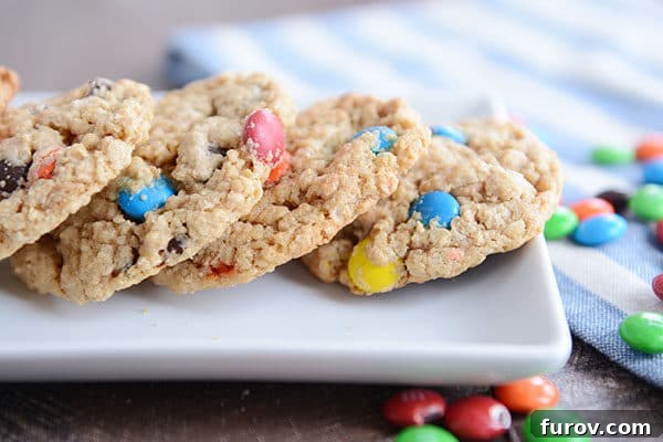 Epic One-Bowl Gluten-Free M&M Monster Cookies 4 A tray filled with freshly baked M&M oat cookies, artfully arranged with additional M&M's sprinkled around the platter for visual appeal.