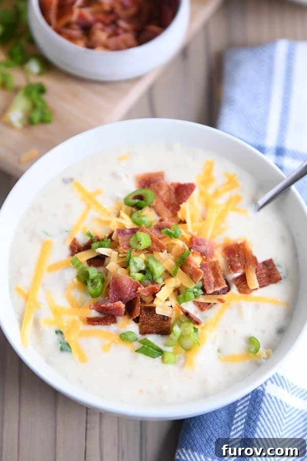 Top down view of easy loaded baked potato soup in white bowl.