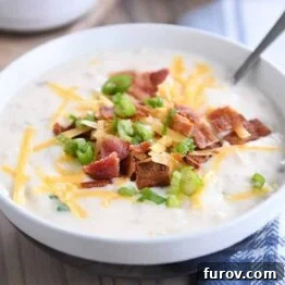 spoon in white bowl with easy loaded baked potato soup