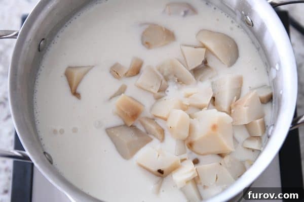 Adding baked potatoes to soup.