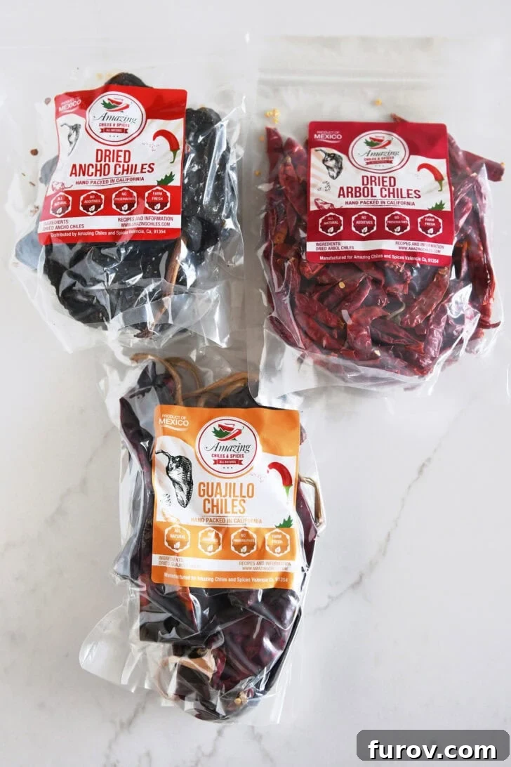 Ultimate Slow Cooker Birria Tacos 3 Dried ancho chiles, dried arbo chiles, and dried guajillo chiles in plastic cellophane bags.
