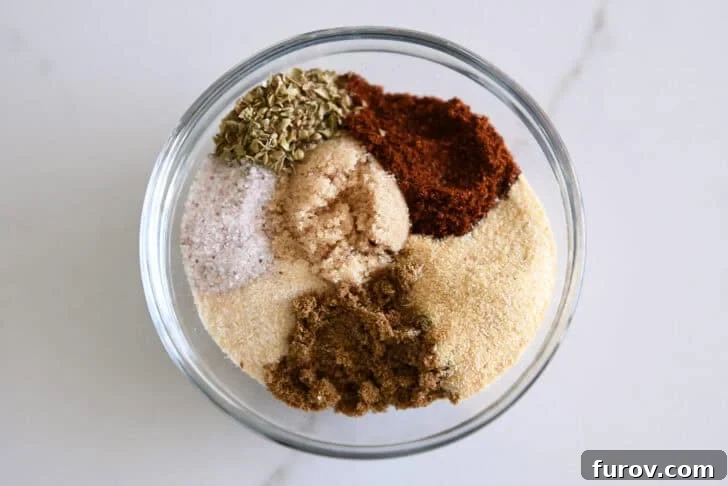 Small glass bowl filled with a blend of chili powder, onion powder, garlic powder, ground cumin, dried oregano, salt, and brown sugar, ready for the enchilada sauce.