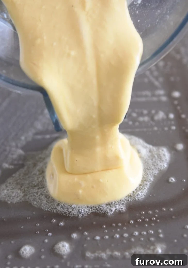 Pouring cottage cheese pancake batter onto a buttered, hot griddle.