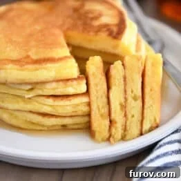 Four triangle slices cut out of stack of four pancakes on gray plate.