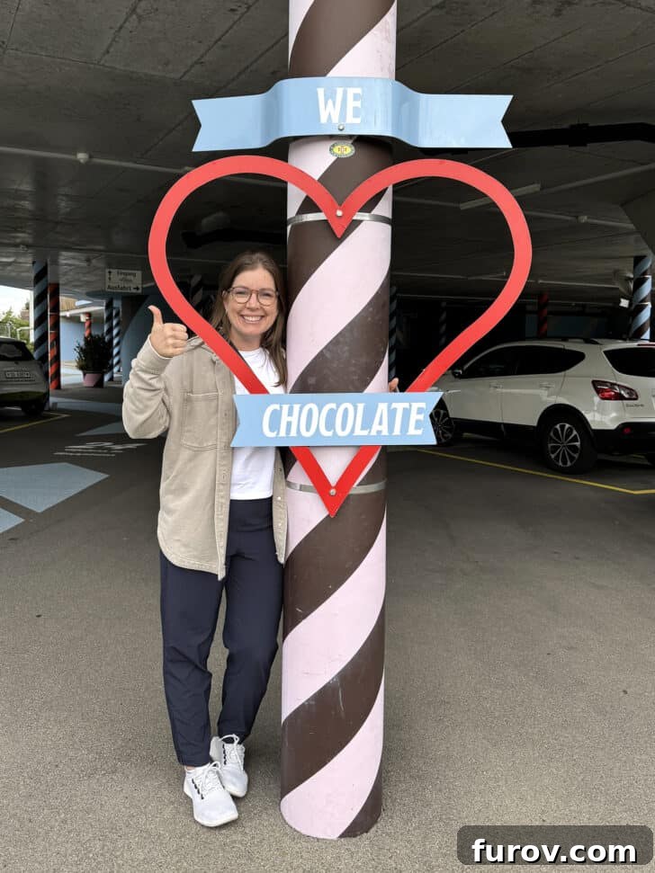 Mel standing in front of a "We love chocolate" sign, with text that mentions Mel\