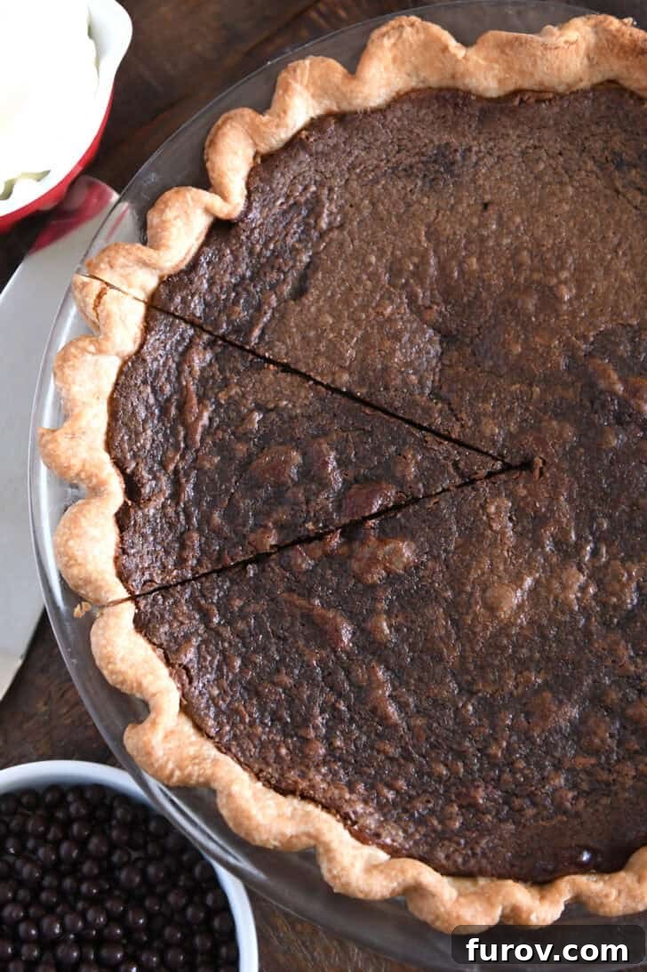 Velvet Chocolate Perfection 6 A top-down perspective of a freshly baked chocolate chess pie, with one delectable slice already cut but still resting within the pie, showcasing its crackly top and rich interior.