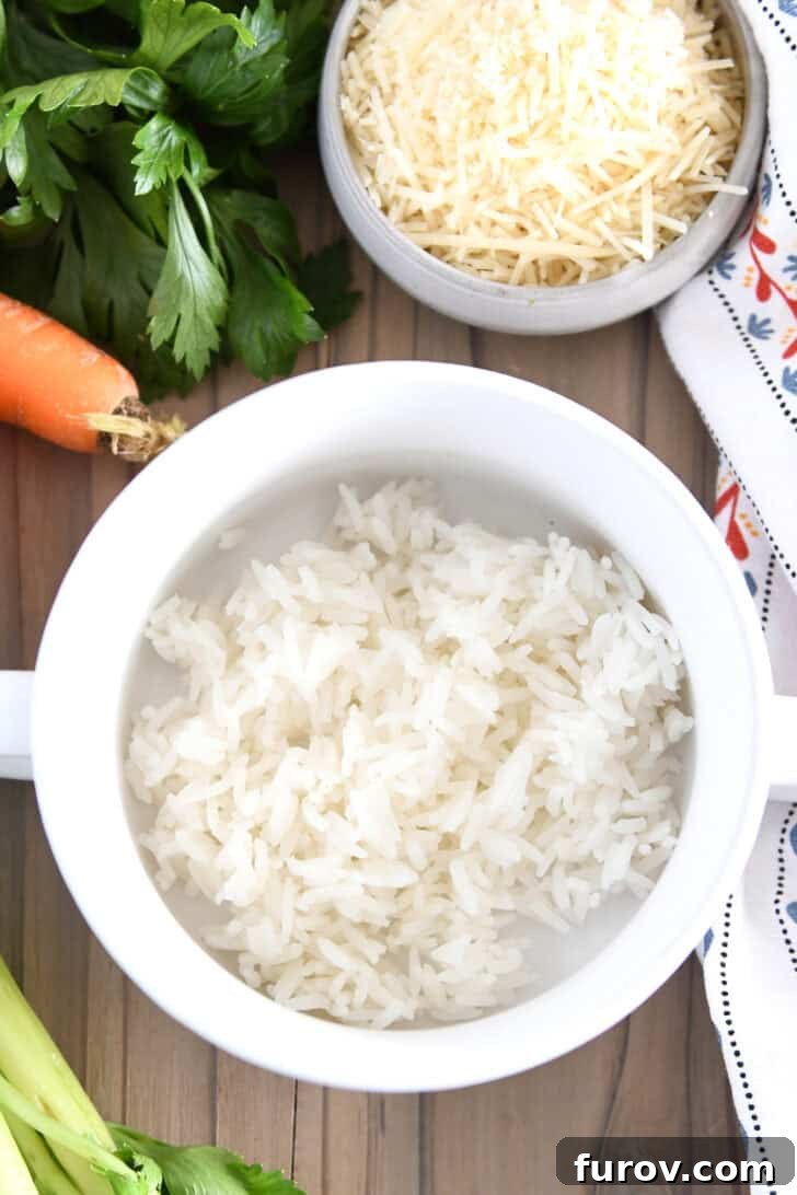 White soup bowl with handles, showing a scoop of perfectly cooked white rice at the bottom, ready for soup.