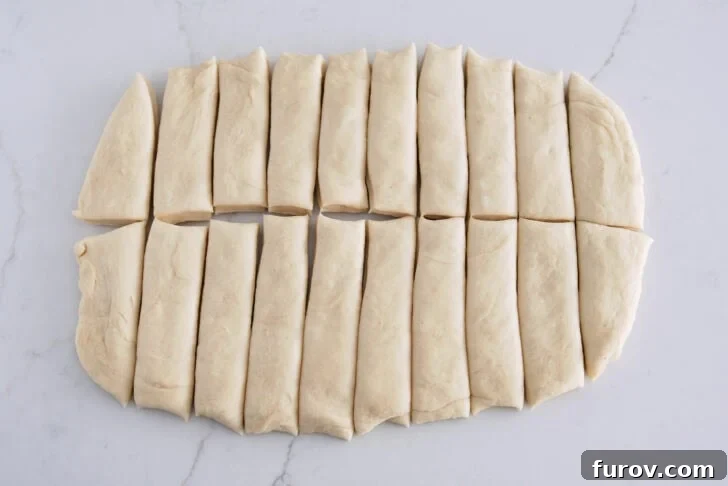 Dough pressed into a thick rectangle and expertly cut into 20 even strips, ready for flavoring.