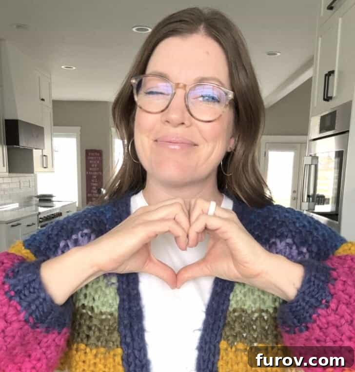 A Friday Medley of Celebrations Questions and Treasures 6 Mel holding up a hand heart gesture, smiling.
