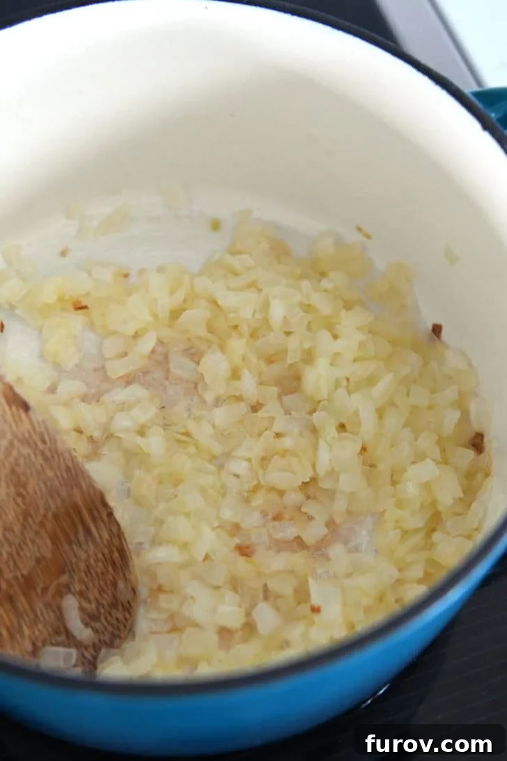 Cast iron enamel pot with cooked onions in butter.