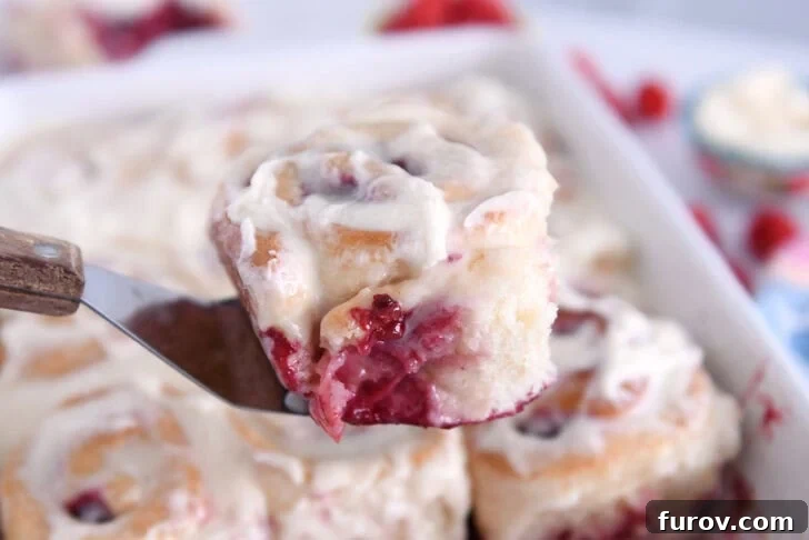 Baked raspberry sweet roll on metal spatula.