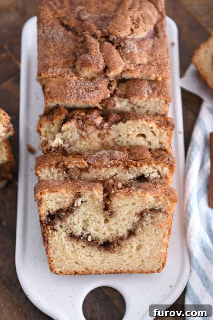 Warm Cinnamon Swirl Loaf 2 White tray with four slices of cinnamon swirl quick bread, showcasing the perfect swirl and crunchy top.