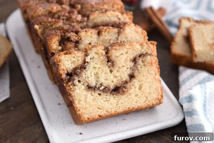 Warm Cinnamon Swirl Loaf 12 Three slices of cinnamon swirl quick bread on white tray, showcasing the moist interior and appealing cinnamon layers.