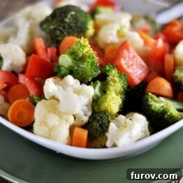 Close-up of a portion of the vegetable sauté with cream sauce in a white bowl.
