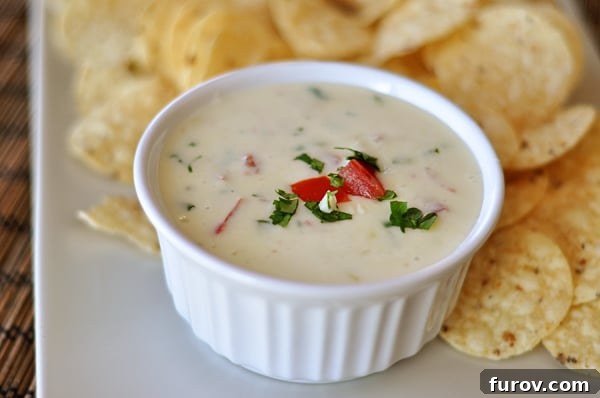 Creamy White Cheese Dip 3 White ramekin with queso blanco dip on a tray surrounded by crispy tortilla chips.