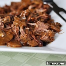 A plate of delicious braised brisket with mushrooms and gravy.
