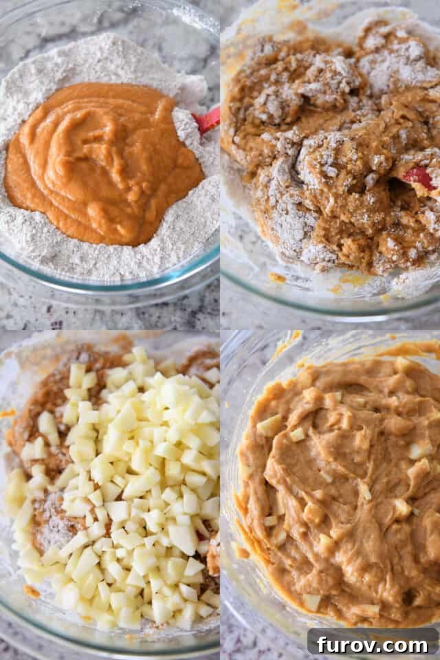 Mixing vibrant orange pumpkin muffin batter with fresh apple pieces in a clear glass bowl, showcasing the rich texture.