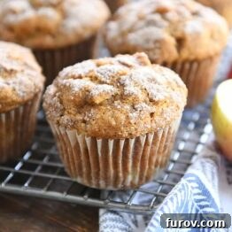 Baked pumpkin apple spice muffins with cinnamon and sugar topping on a cooling rack, ready to be enjoyed.
