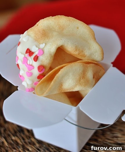 A white paper container full of freshly cooked homemade fortune cookies, ready to be presented.