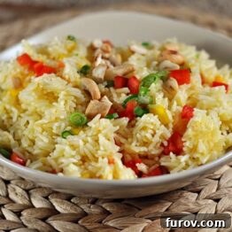 Vibrant Orange Cashew Rice with Baked Tilapia presented beautifully in a dish.