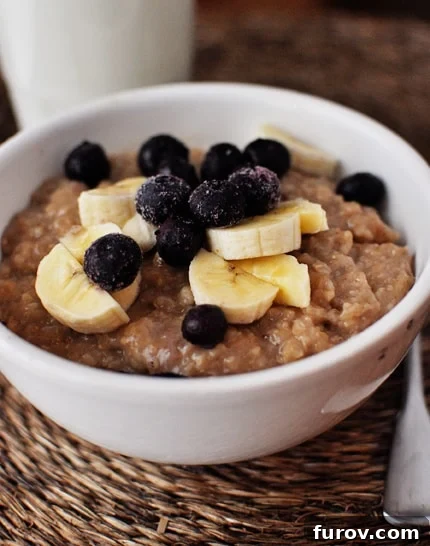 Sweet Maple Brown Sugar Overnight Oats 2 White bowl of cooked oatmeal topped with bananas and blueberries. A perfect example of a healthy and easy overnight breakfast.