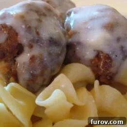 A dish of tender meatballs covered in a rich, creamy sauce.