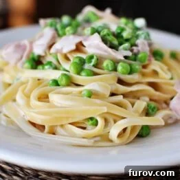 Creamy Fettuccine with Ham and Peas on a white plate
