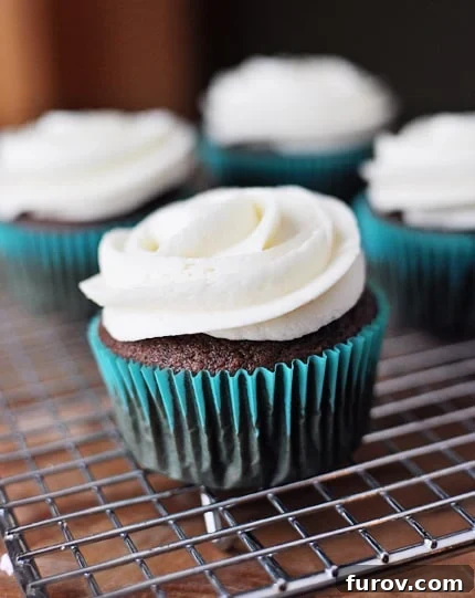 Beautifully frosted chocolate cupcakes with a elegant swirl on a wire cooling rack, ready to be served.