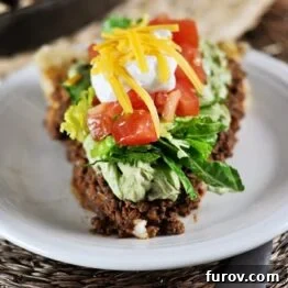 A vibrant slice of Skillet Taco Pie with layered ingredients and fresh toppings.