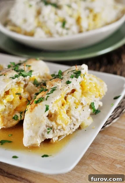 White platter with apple-stuffed chicken breasts topped with fresh parsley, showcasing a unique and delicious dinner option.