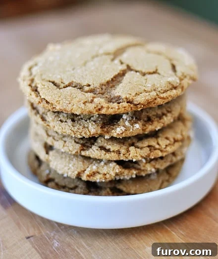 A charming stack of ginger crinkle cookies arranged in a small white ramekin, highlighting their beautiful golden-brown color and soft texture.