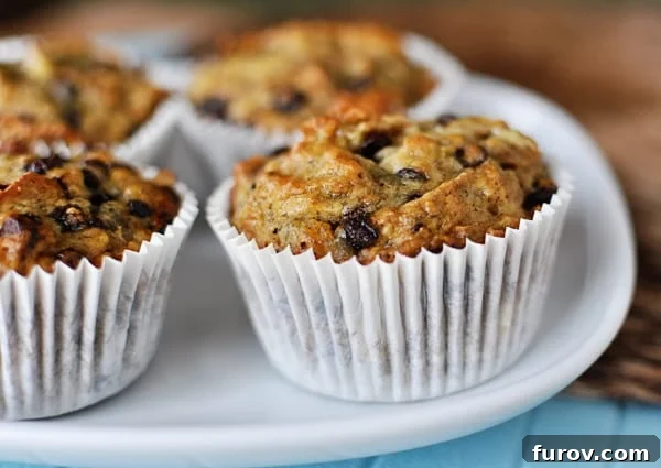 Wholesome Banana Bran Muffins 4 A trio of freshly baked, wholesome banana bran muffins in white paper liners, ready to be served.
