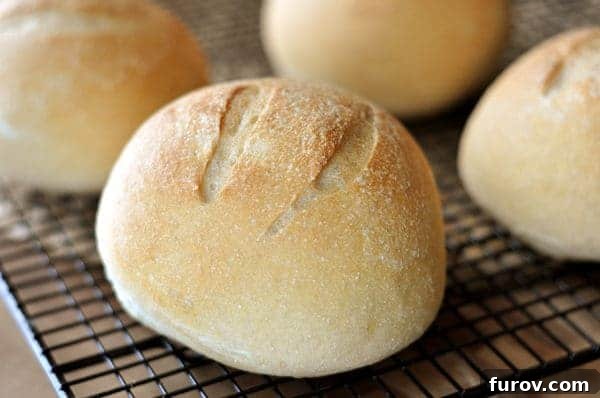 Golden brown bread bowls on a cooling rack.