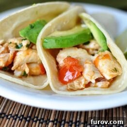 A freshly prepared plate of Skillet Cilantro and Lime Fish Tacos, garnished with fresh herbs and lime.