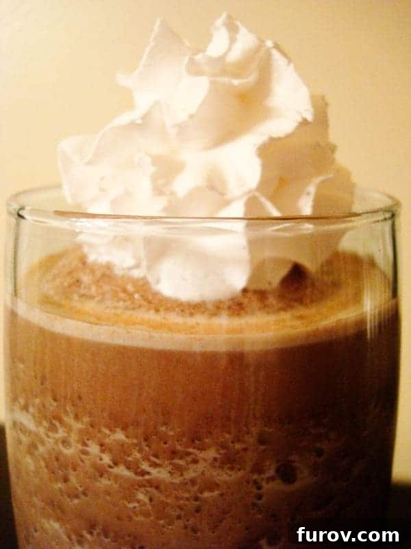 Glass of frozen hot chocolate with whipped cream on top, ready to be enjoyed.