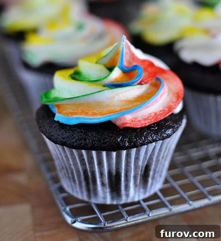 Close-up shot of chocolate cupcakes with tie-dye frosting on a cooling rack, showcasing the intricate patterns of the colorful buttercream.