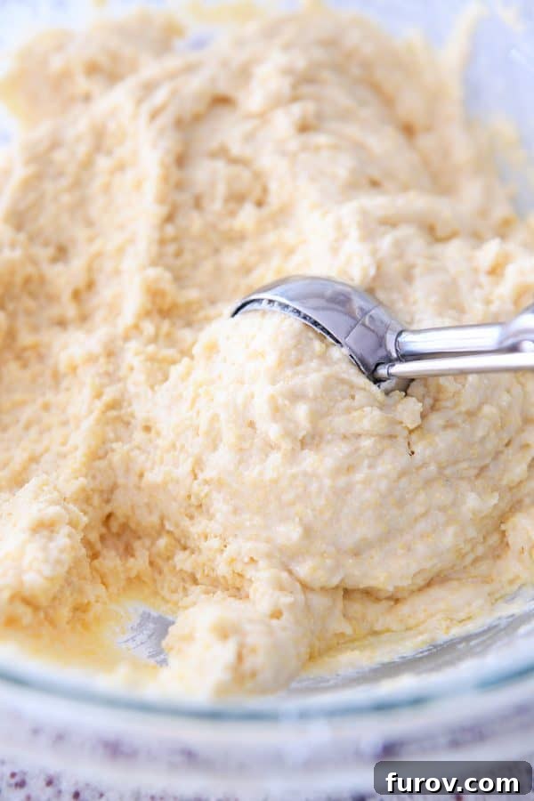 Scooping cornbread muffin batter with cookie scoop.