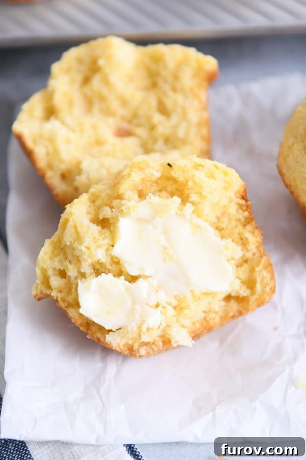 Cornbread muffin split in half with butter.