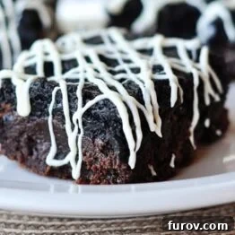 A perfectly portioned Oreo Truffle Brownie, topped with white chocolate drizzle.