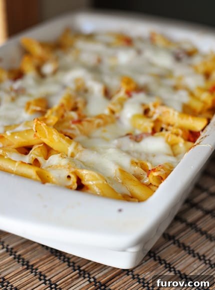 White casserole dish full of baked cheesy pasta, hot and bubbly from the oven.