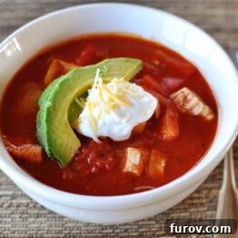 Red Chicken Chili served with fresh garnishes.